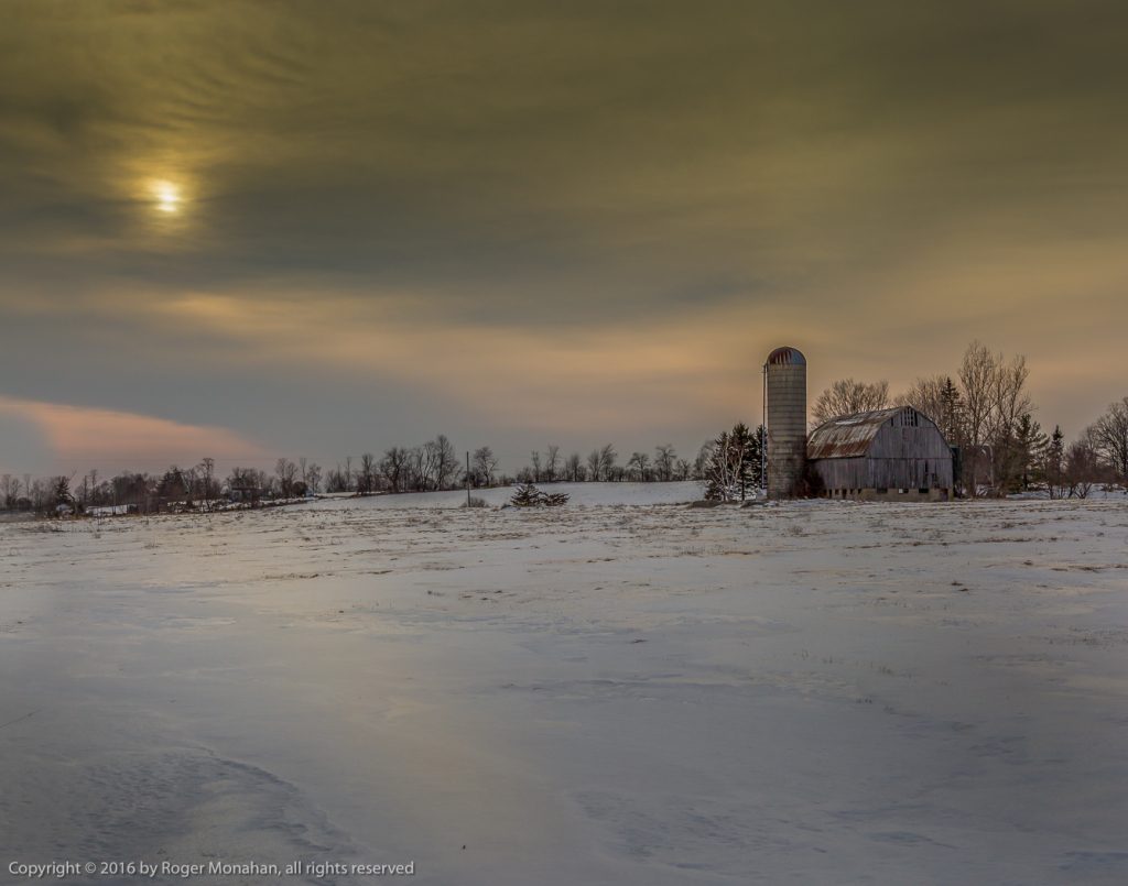 Barn caught in the stark light of an overcast winter sunset.