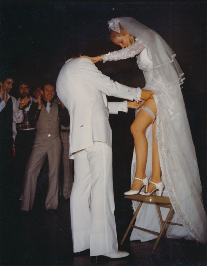 Removal of the garter with Bride standing on a chair.